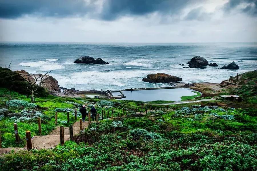 Hikers explore San Francisco's Sutro Baths near the Pacific Ocean