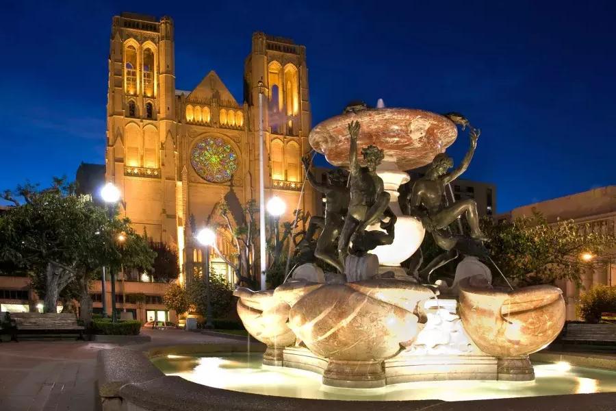 La cathédrale Grace de San Francisco est représentée la nuit avec une fontaine ornée au premier plan.