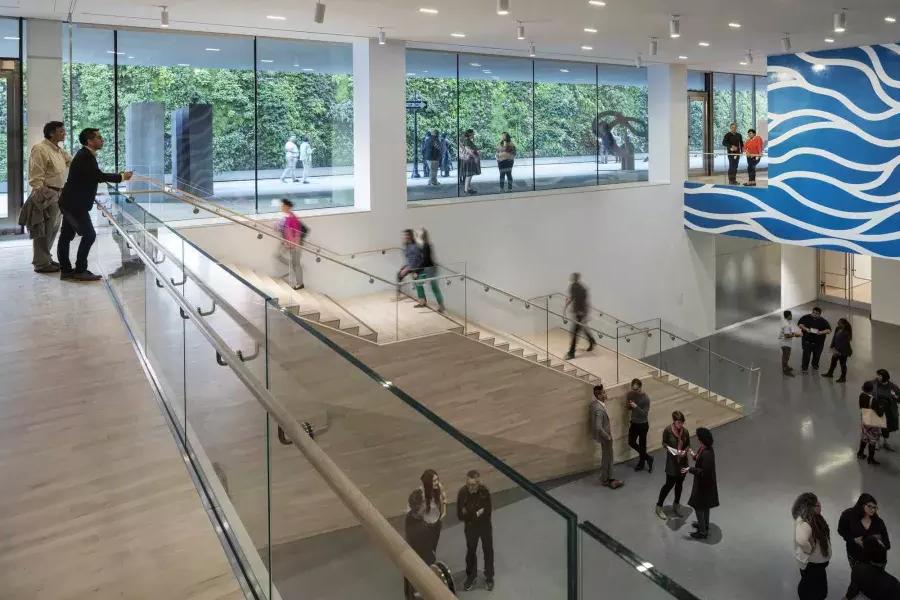 In einem luftigen Atrium im San Francisco Museum of Modern Art (SFMOMA) gehen Menschen Treppen hinauf und hinunter.